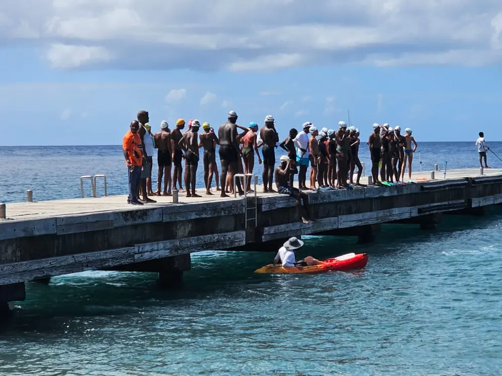 Le groupe de nageurs réuni sur un ponton, un kayak rouge à ses pieds