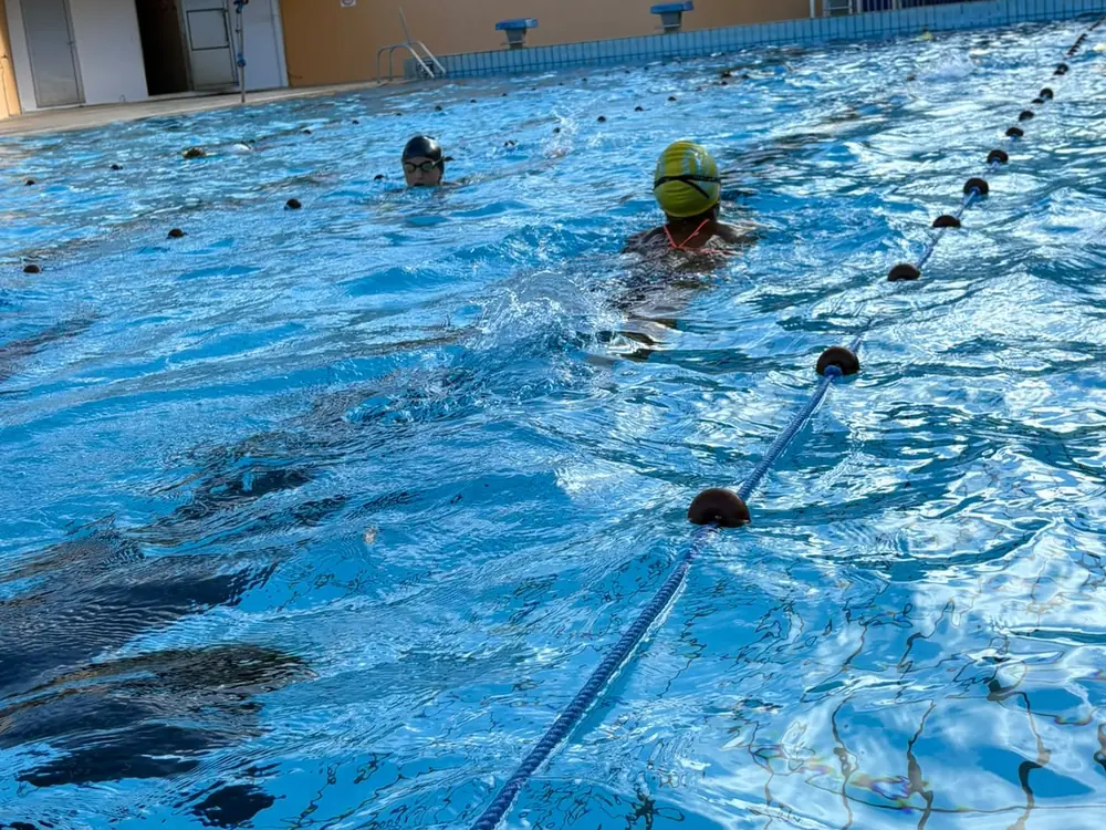 Un nageur en bonnet jaune dans une ligne d'eau de la piscine du François