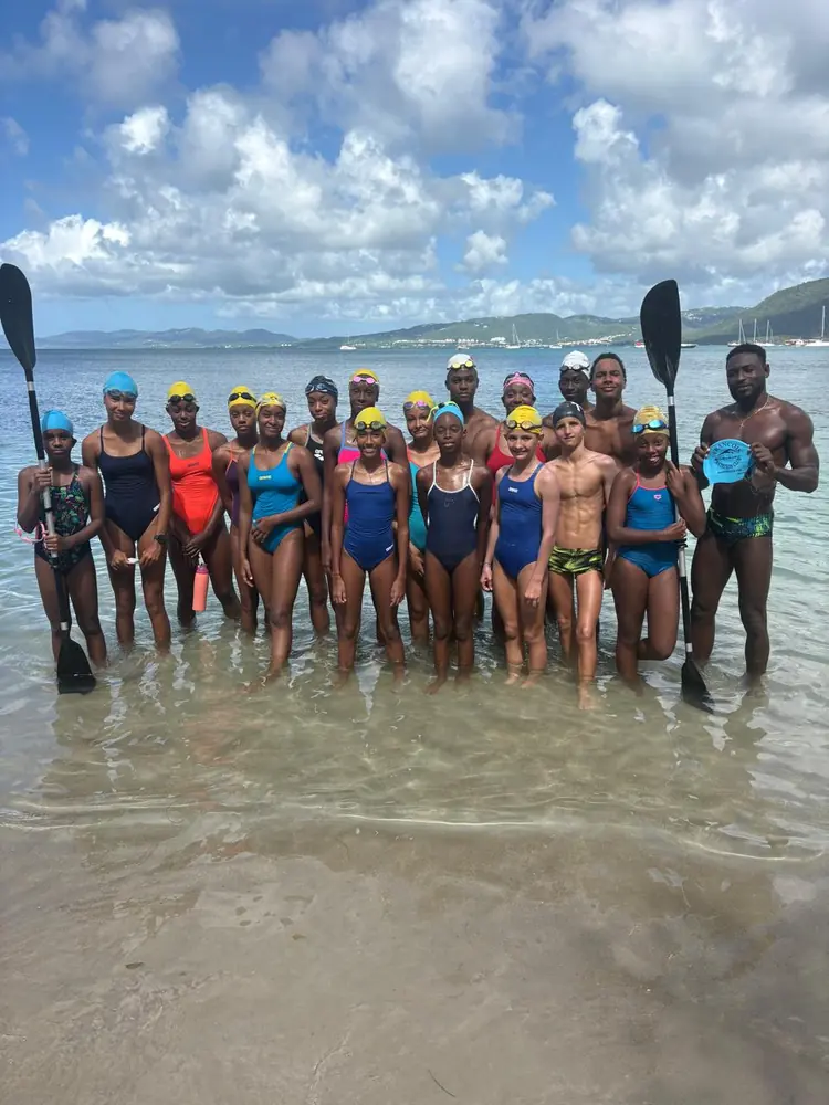 Le groupe de nageurs à la Pointe Marin, encadré par deux adultes qui tiennent une pagaie de kayak